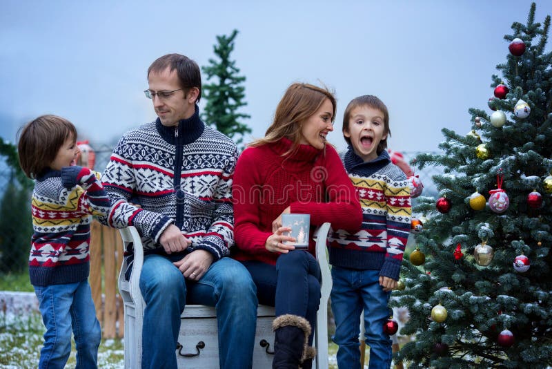 Familia de cuatro miembros feliz hermosa, divirtiéndose al aire libre en la nieve foto de archivo libre de regalías Familia de cuatro miembros feliz hermosa, divirtiéndose al aire libre en la nieve foto de archivo libre de regalías