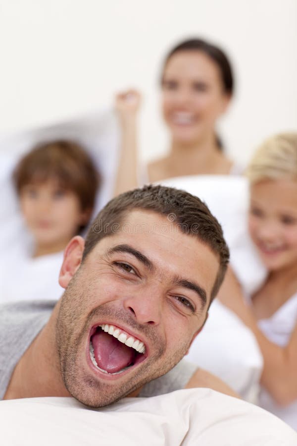 Familia de Smilling que tiene una lucha de almohadilla imagenes de archivo Familia de Smilling que tiene una lucha de almohadilla imagenes de archivo