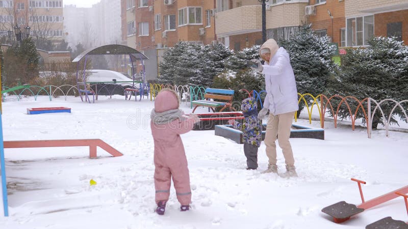 Familia de tres personas disfrutando de un día de invierno en el patio de los edificios de altura. vacaciones de invierno divertid