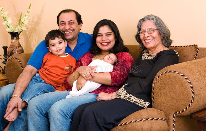 An East-Indian family sits in their living room. An East-Indian family sits in their living room