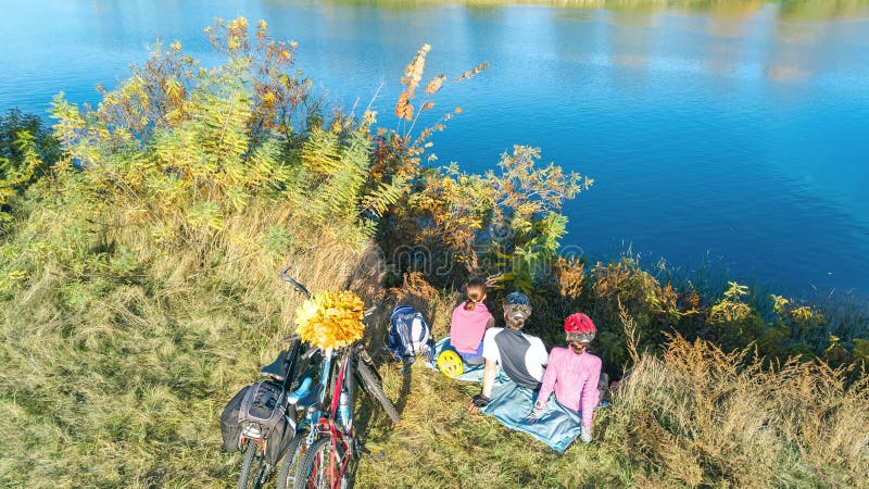 Familia el otoño de las bicis que completa un ciclo al aire libre, padres y niño activos en las bicicletas, opinión aérea la fami fotos de archivo Familia el otoño de las bicis que completa un ciclo al aire libre, padres y niño activos en las bicicletas, opinión aérea la fami fotos de archivo