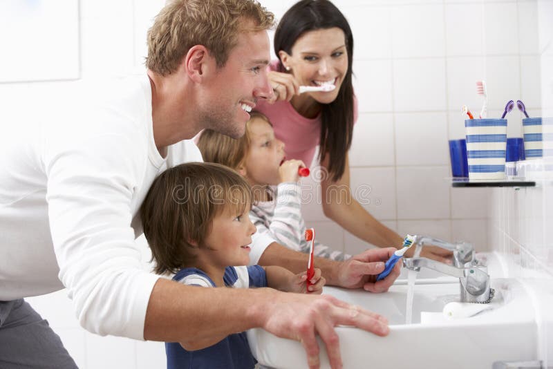 Familia en dientes de cepillado del cuarto de baño