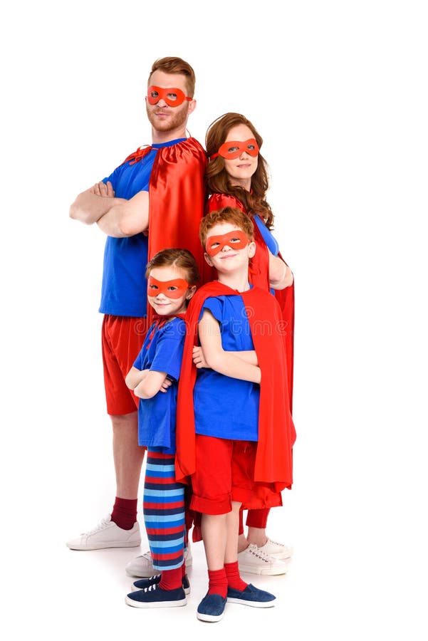 Familia estupenda en los trajes que se colocan con los brazos cruzados y que miran la cámara imagenes de archivo