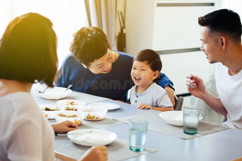 Familia extensa asiática feliz que cena en casa por completo de la risa y de la felicidad foto de archivo Familia extensa asiática feliz que cena en casa por completo de la risa y de la felicidad foto de archivo