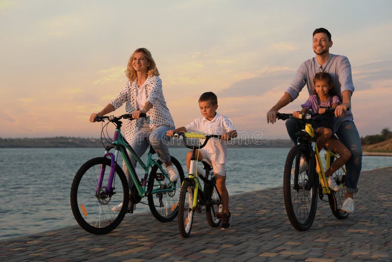 Familia feliz con niños en bicicleta cerca del rÃo imagenes de archivo Familia feliz con niños en bicicleta cerca del rÃo imagenes de archivo