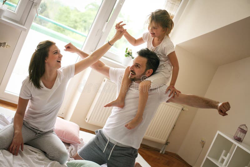 Familia feliz con una hija que pasa tiempo en casa fotos de archivo Familia feliz con una hija que pasa tiempo en casa fotos de archivo