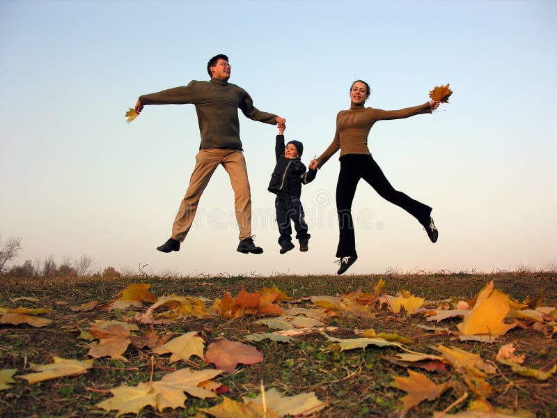 Familia feliz de la mosca con las hojas de otoño fotografía de archivo libre de regalías Familia feliz de la mosca con las hojas de otoño fotografía de archivo libre de regalías