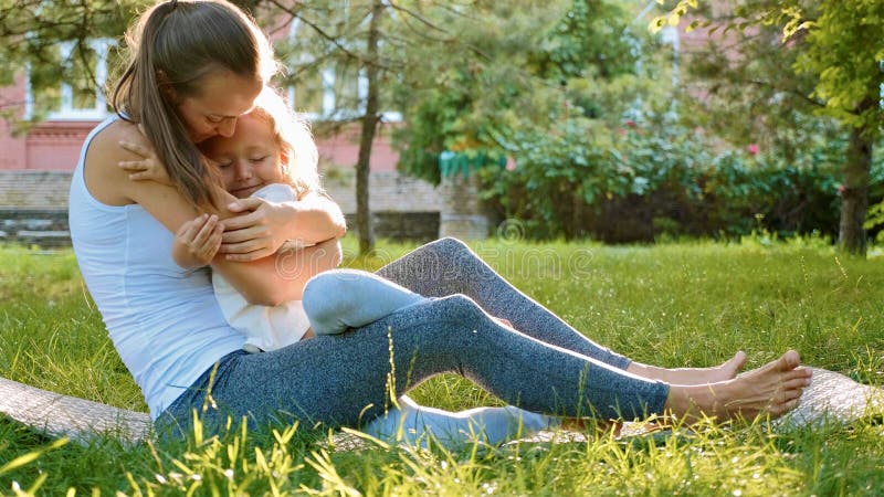 Familia feliz de madre deportiva joven y pequeña de hija linda que se divierten al aire libre fotos de archivo Familia feliz de madre deportiva joven y pequeña de hija linda que se divierten al aire libre fotos de archivo