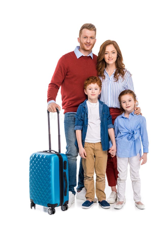 Familia feliz del pelirrojo con la maleta que se une y que sonríe en la cámara imagen de archivo