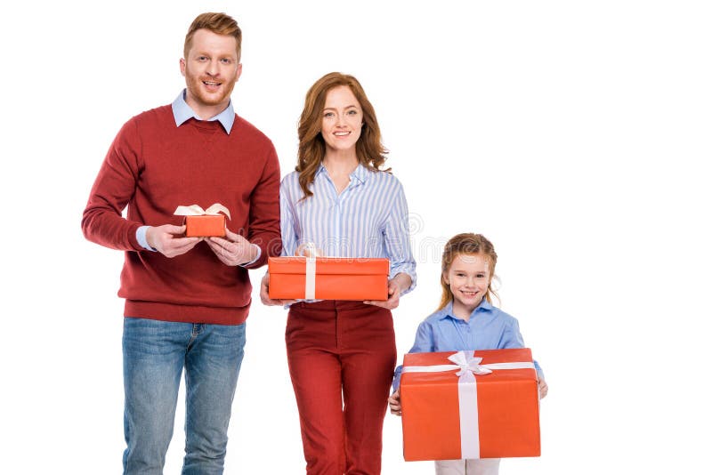 Familia feliz del pelirrojo que sostiene las cajas de regalo y que sonríe en la cámara fotografía de archivo
