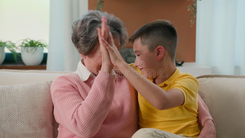 Familia feliz dos generaciones cariñosa mujer de 70 años abuela pensionada pasando tiempo con nieto niño en casa