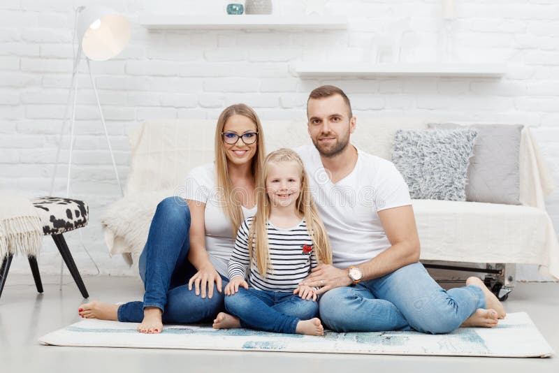 Familia feliz en casa que se sienta en piso imagen de archivo libre de regalías Familia feliz en casa que se sienta en piso imagen de archivo libre de regalías