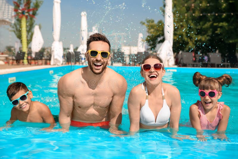 Familia feliz en la piscina durante el día foto de archivo libre de regalías