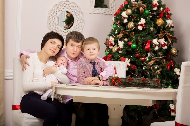 Familia feliz en la tabla del día de fiesta Árbol Navidad foto de archivo Familia feliz en la tabla del día de fiesta Árbol Navidad foto de archivo