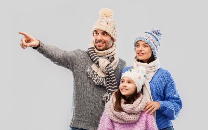 Familia feliz en ropa del invierno en fondo gris imagenes de archivo Familia feliz en ropa del invierno en fondo gris imagenes de archivo