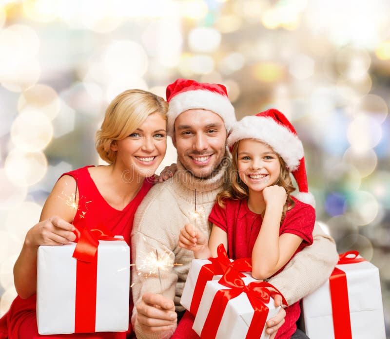 Familia feliz en sombreros del ayudante de santa con las cajas de regalo imagen de archivo Familia feliz en sombreros del ayudante de santa con las cajas de regalo imagen de archivo