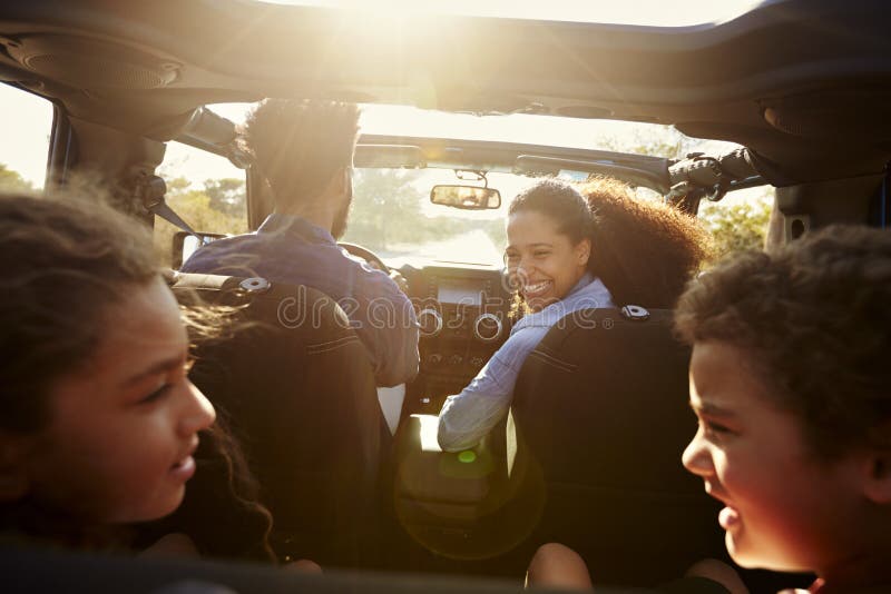 Familia feliz en un viaje por carretera en su coche, pasajero posterior POV