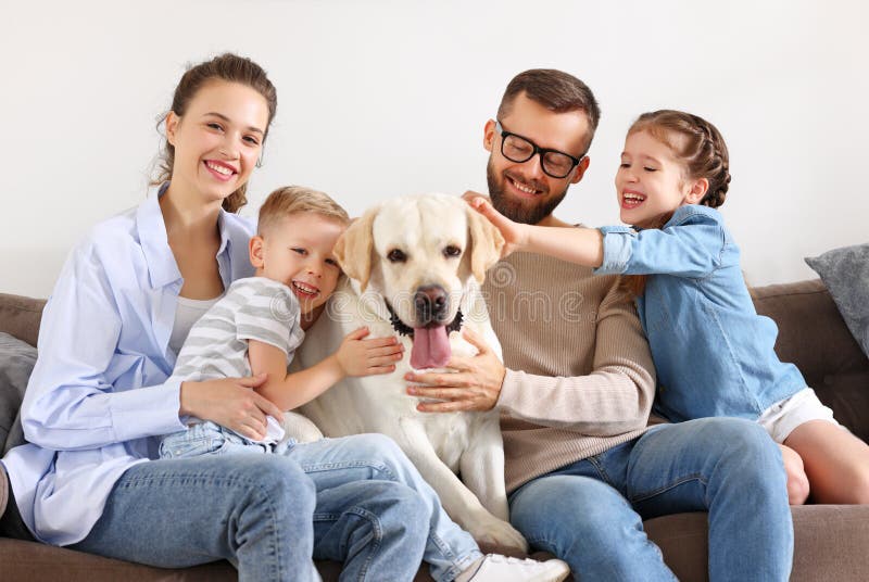 Happy family: parent with cheerful kids playing with their favorite pet dog labrador at home. Happy family: parent with cheerful kids playing with their favorite pet dog labrador at home