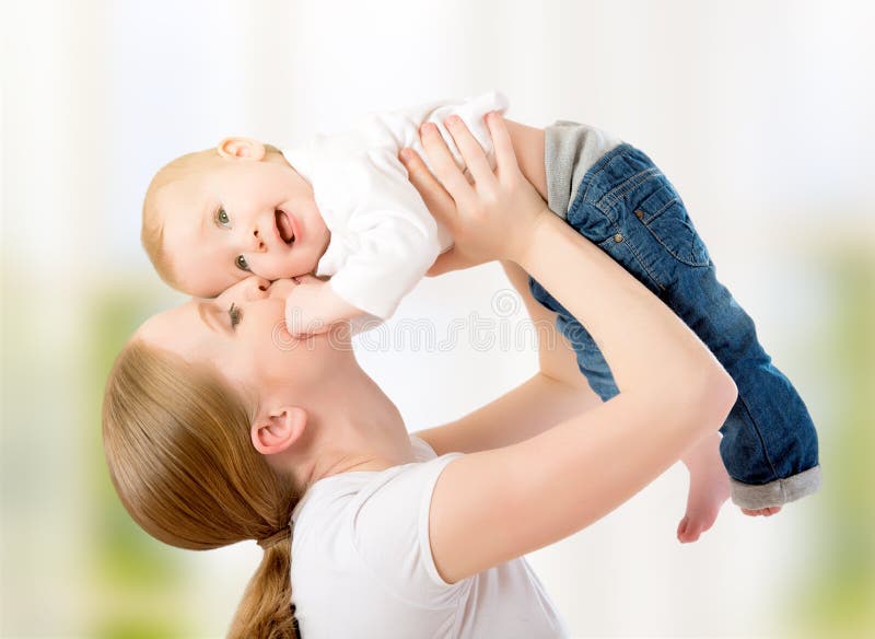 Familia feliz. La madre lanza para arriba al bebé, jugando imagenes de archivo