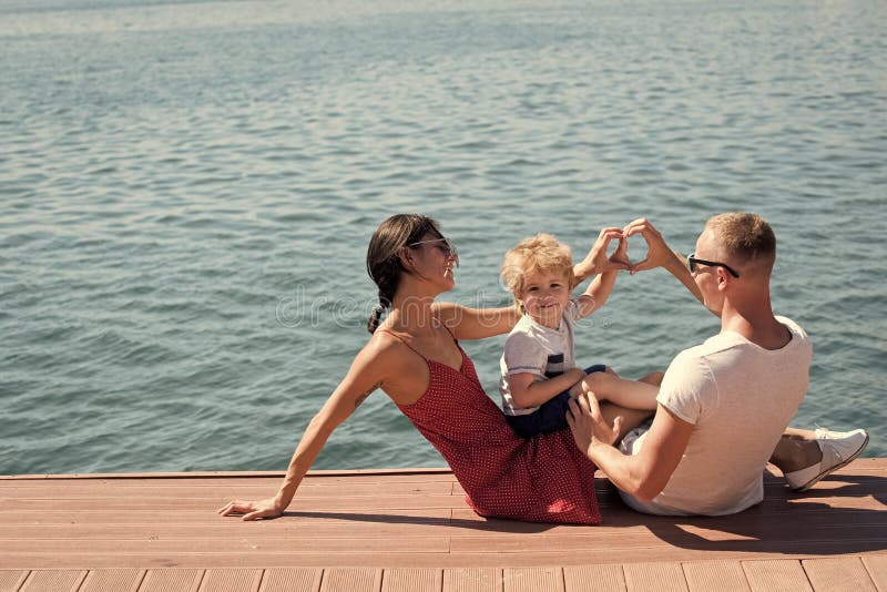 Familia feliz Madre y padre que hacen gesto del corazón o del amor con las manos cerca de su niño La familia feliz pasa tiempo fotografía de archivo libre de regalías Familia feliz Madre y padre que hacen gesto del corazón o del amor con las manos cerca de su niño La familia feliz pasa tiempo fotografía de archivo libre de regalías