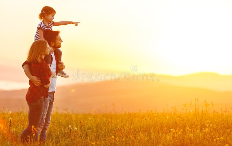 Familia feliz: padre de la madre e hija del niño en puesta del sol