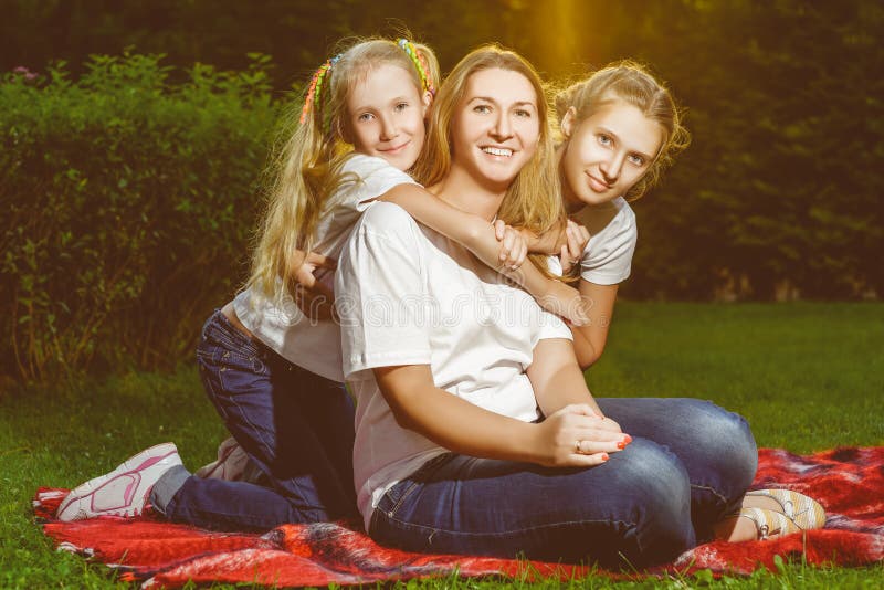 Familia feliz que miente en la hierba en verano Comida campestre imagen de archivo libre de regalías Familia feliz que miente en la hierba en verano Comida campestre imagen de archivo libre de regalías