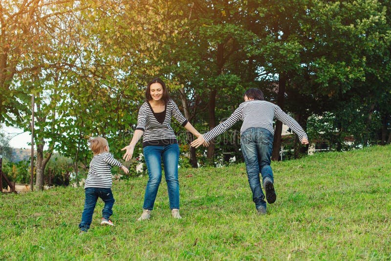 Familia feliz que se divierte al aire libre Familia joven que disfruta de vida, junto en la naturaleza Forma de vida feliz de la fotografía de archivo libre de regalías