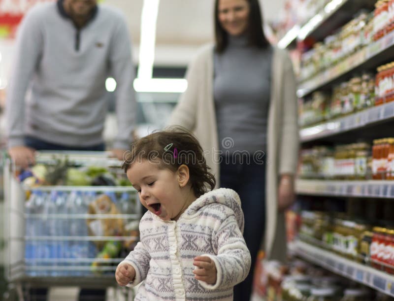Familia feliz que se divierte en el supermercado imagenes de archivo Familia feliz que se divierte en el supermercado imagenes de archivo
