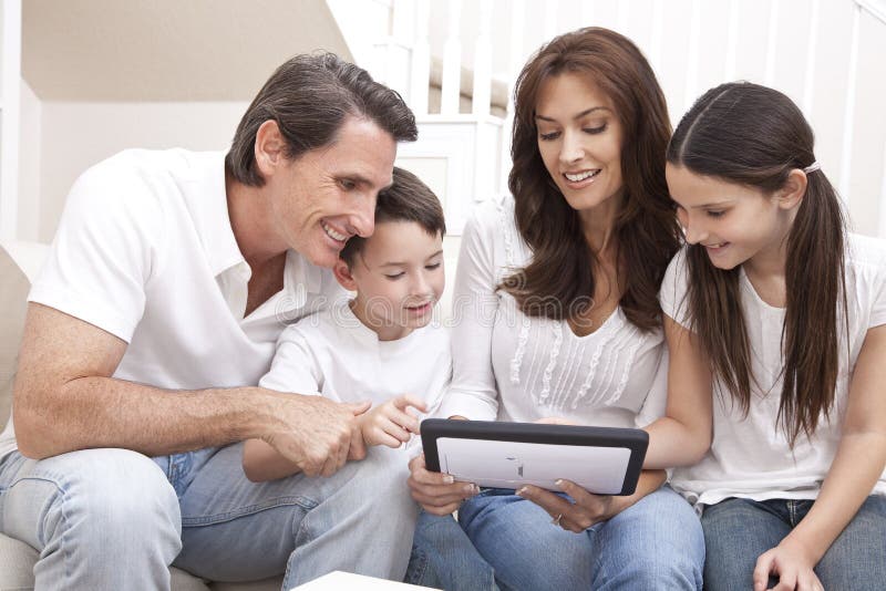 Familia feliz que se divierte usando el ordenador de la tablilla imagenes de archivo Familia feliz que se divierte usando el ordenador de la tablilla imagenes de archivo