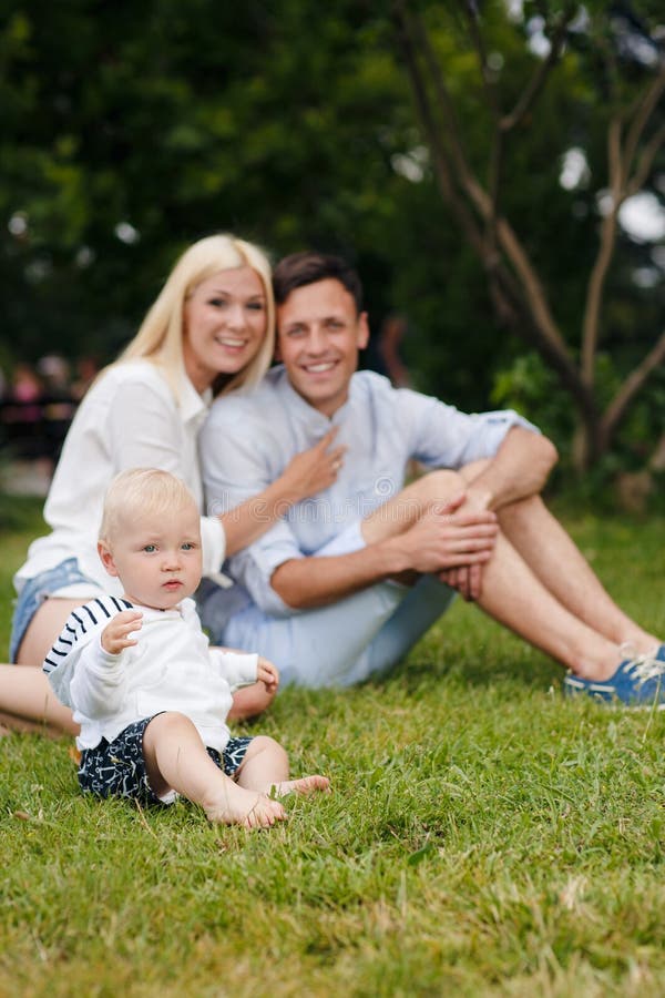 Familia feliz que se relaja en el parque del verano fotos de archivo libres de regalías Familia feliz que se relaja en el parque del verano fotos de archivo libres de regalías