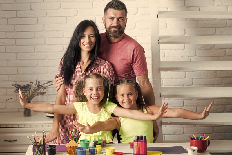 Familia feliz que sonríe en la tabla con las pinturas coloridas fotografía de archivo Familia feliz que sonríe en la tabla con las pinturas coloridas fotografía de archivo