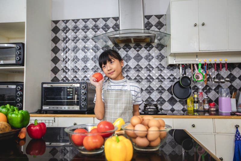 Familia feliz y su pequeña hija que cocinan junto en la cocina foto de archivo libre de regalías Familia feliz y su pequeña hija que cocinan junto en la cocina foto de archivo libre de regalías