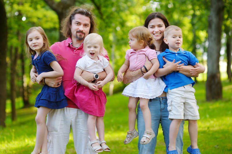 Familia grande feliz de seis en el parque del verano foto de archivo Familia grande feliz de seis en el parque del verano foto de archivo