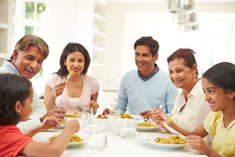 Familia india de la generación multi que come la comida en casa