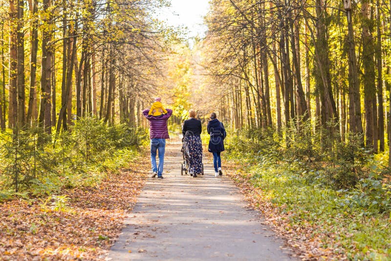 Familia joven al aire libre que camina a través de Autumn Park