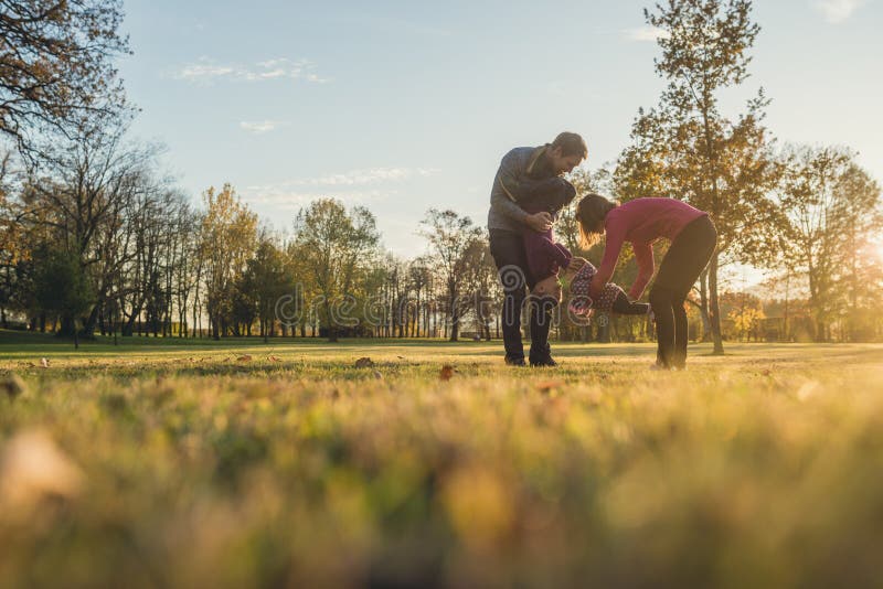 Familia joven con dos niños que se divierten en un parque fotos de archivo libres de regalías Familia joven con dos niños que se divierten en un parque fotos de archivo libres de regalías