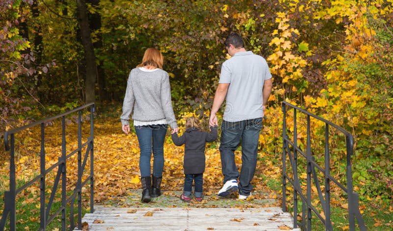 Familia joven feliz en el otoño que hace una excursión fotos de archivo libres de regalías Familia joven feliz en el otoño que hace una excursión fotos de archivo libres de regalías