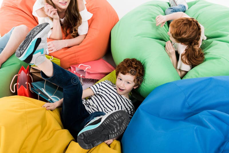 familia joven feliz que descansa sobre sillas del puf después de hacer compras imágenes de archivo libres de regalías familia joven feliz que descansa sobre sillas del puf después de hacer compras imágenes de archivo libres de regalías