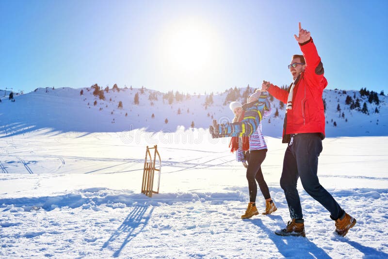 Familia joven feliz que juega en nieve fresca en el día de invierno soleado hermoso al aire libre en naturaleza foto de archivo Familia joven feliz que juega en nieve fresca en el día de invierno soleado hermoso al aire libre en naturaleza foto de archivo