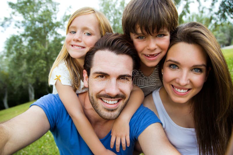 Familia joven feliz que toma selfies con su smartphone en el par imagen de archivo libre de regalías