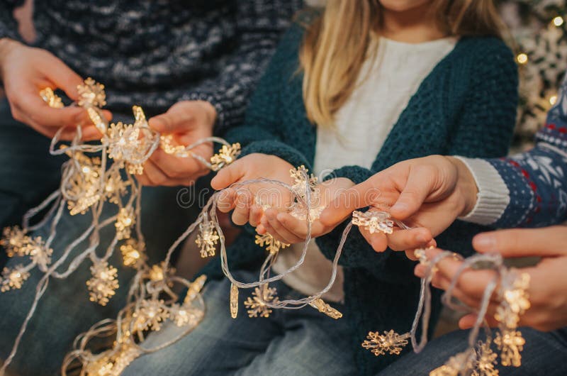 Familia joven hermosa que disfruta de su tiempo del día de fiesta junto, adornando el árbol de navidad, arreglando las luces de l foto de archivo libre de regalías Familia joven hermosa que disfruta de su tiempo del día de fiesta junto, adornando el árbol de navidad, arreglando las luces de l foto de archivo libre de regalías