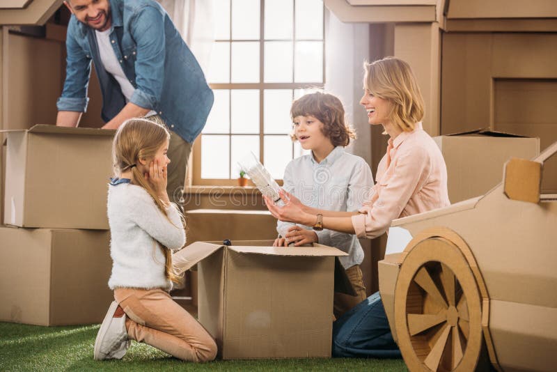 familia joven que desempaqueta las cajas mientras que se traslada a nuevo foto de archivo familia joven que desempaqueta las cajas mientras que se traslada a nuevo foto de archivo