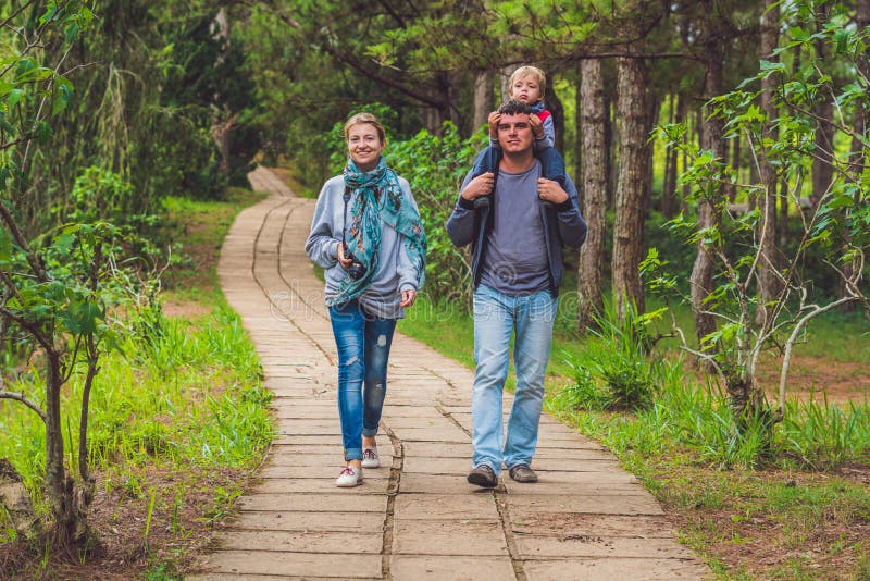 Familia, madre, padre e hijo, caminando la trayectoria del parque imagenes de archivo Familia, madre, padre e hijo, caminando la trayectoria del parque imagenes de archivo