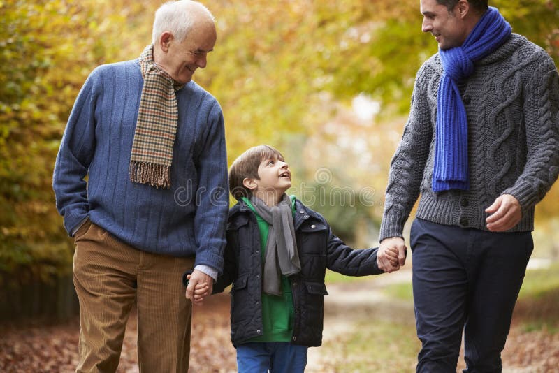 Familia masculina de la generación de Multl que camina a lo largo de Autumn Path fotografía de archivo libre de regalías Familia masculina de la generación de Multl que camina a lo largo de Autumn Path fotografía de archivo libre de regalías
