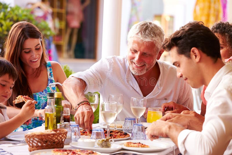 Familia multi de la generación que come la comida en el restaurante al aire libre