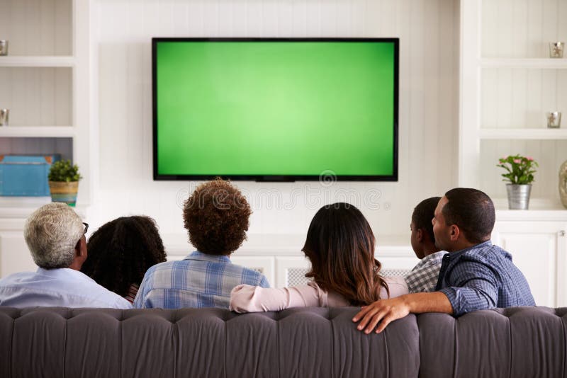 Familia multi de la generación que ve la TV en casa, visión trasera