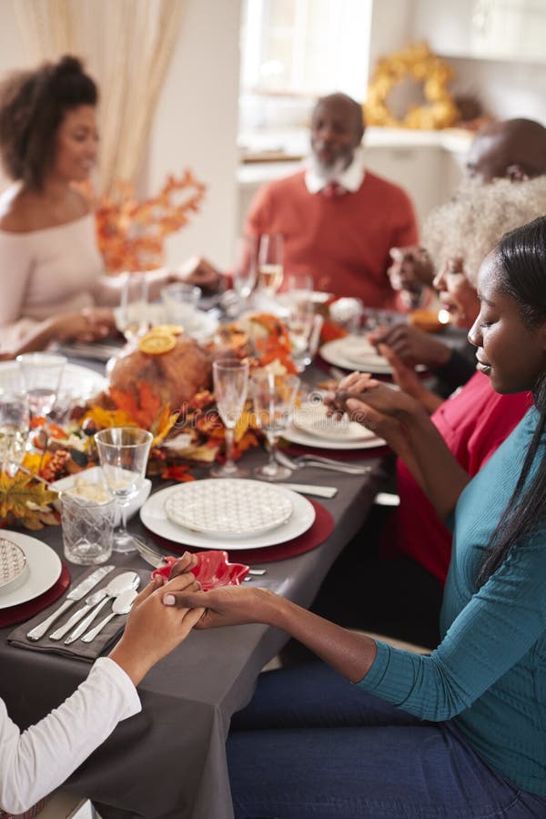 Familia multi de la raza mixta de la generación que lleva a cabo las manos y que dice tolerancia antes de comer en su tabla de ce fotos de archivo libres de regalías Familia multi de la raza mixta de la generación que lleva a cabo las manos y que dice tolerancia antes de comer en su tabla de ce fotos de archivo libres de regalías