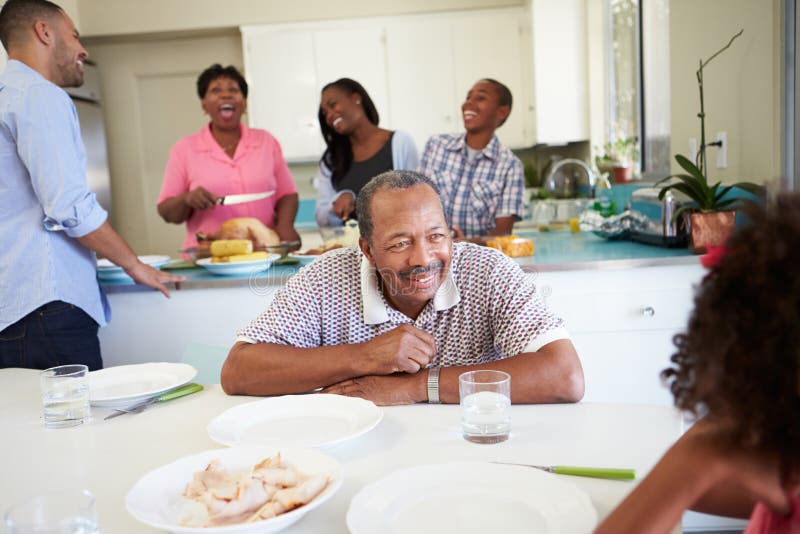 Familia multigeneración que se prepara para la comida en casa imagen de archivo Familia multigeneración que se prepara para la comida en casa imagen de archivo