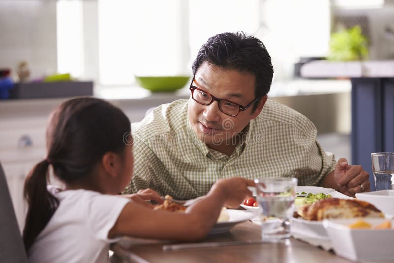 Familia que come la comida en casa junto fotos de archivo Familia que come la comida en casa junto fotos de archivo