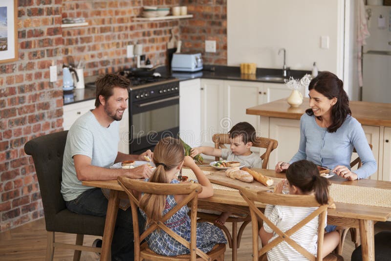 Familia que come la comida en cocina abierta del plan junto foto de archivo Familia que come la comida en cocina abierta del plan junto foto de archivo